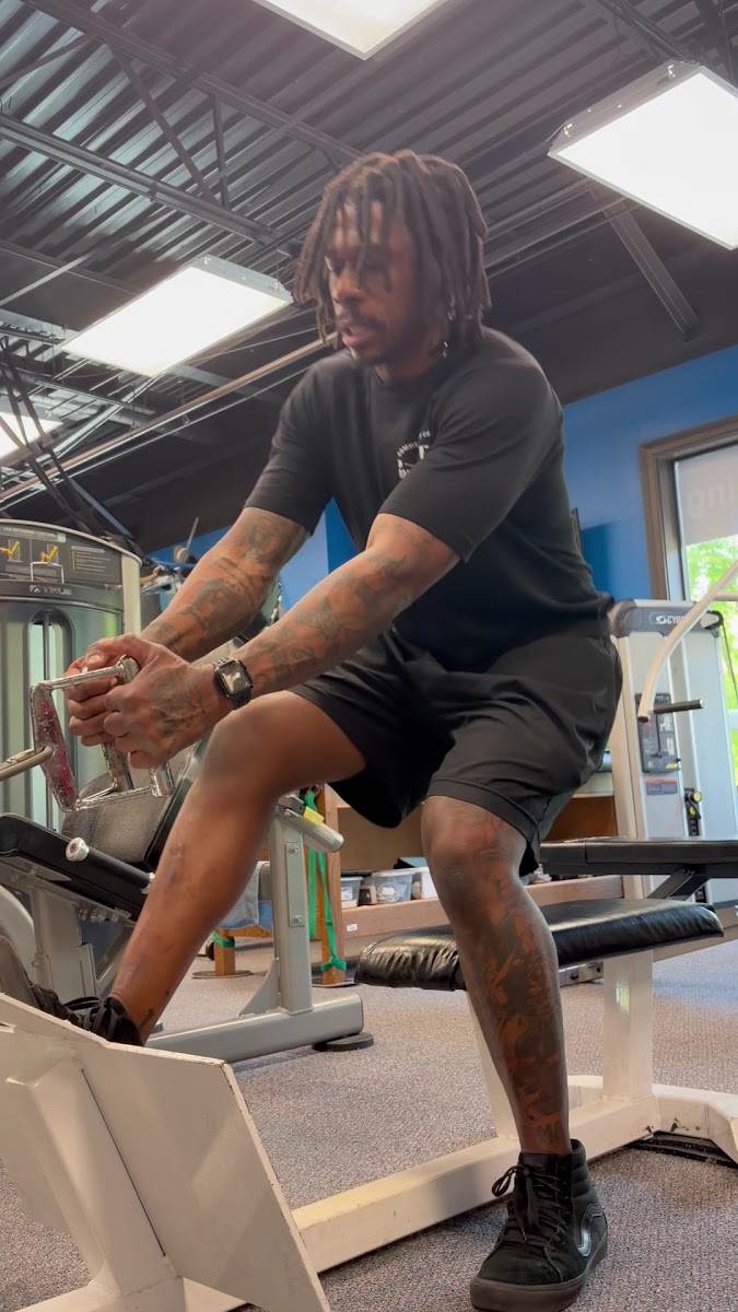 Client doing a seated cable row in a blue-walled studio