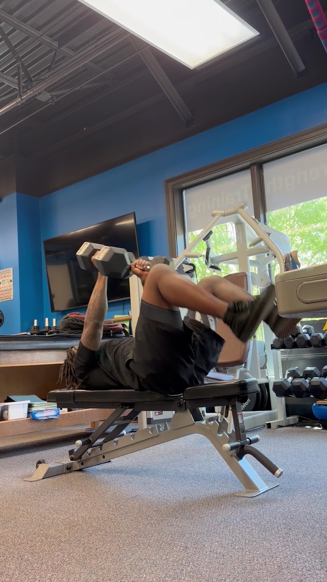 Client pressing dumbbells on an adjustable bench